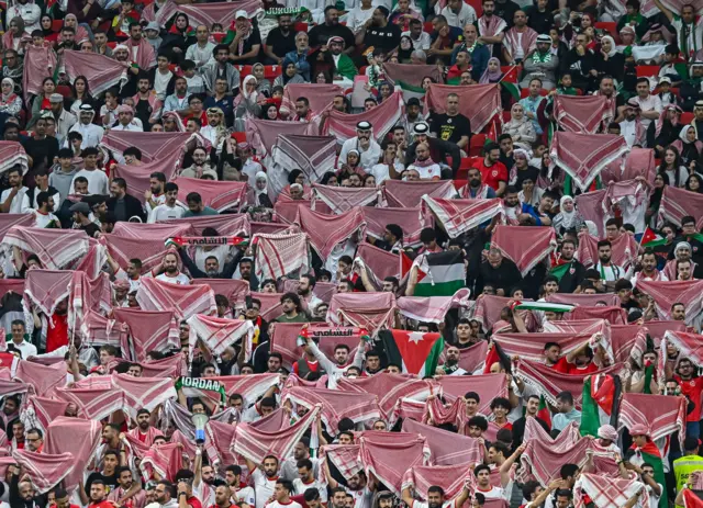 مشجعون أردنيون يرفعون الشماغ خلال مباراة نصف نهائي كأس العرب قطر 2025 بين الأردن والسعودية على ملعب عربايت  